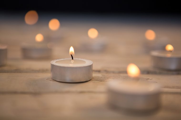 Candles burning on wooden plank during christmas time